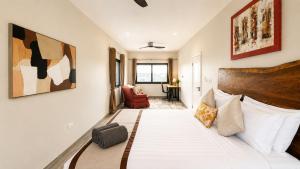 a bedroom with a large bed and a chair at Teranga Tides in Bijilo +23 photos