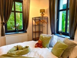 a teddy bear sitting on a bed in a bedroom at Apartmány CHATTA in Horní Maršov +21 photos