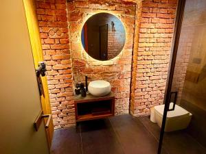 a bathroom with a sink and a mirror on a brick wall at Apartmány CHATTA in Horní Maršov