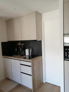 a kitchen with white cabinets and a counter top at Le 400 BIS in Bourg-Saint-Maurice