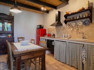 a kitchen with a table and a red refrigerator at Casa del boscaiolo in Trevi