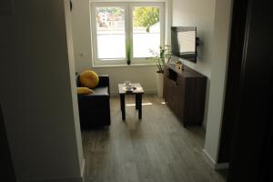 a living room with a couch and a table and a window at BSApartament in Piwniczna-Zdrój