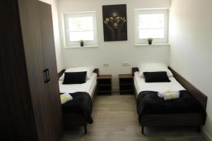 a room with three beds and two windows at BSApartament in Piwniczna-Zdrój