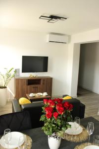 a living room with a table with a vase of red roses at BSApartament in Piwniczna-Zdrój +11 photos