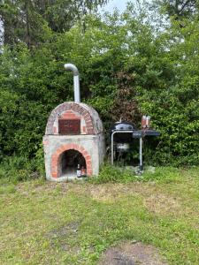 a brick oven with a grill in a field at Naturunterkunft Leonberg in Leonberg