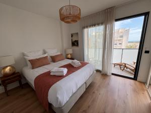 a bedroom with a large bed and a large window at Villa Lagoon in Carnon-Plage