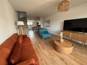 a living room with a couch and a large screen tv at Villa Lagoon in Carnon-Plage