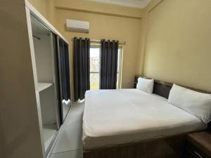 a bedroom with a large bed with a window at Aluruba Residence in Mogadishu