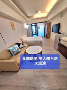 a living room with a couch and a sign at Capybara樓中樓湯屋 in Jiaoxi