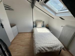 a small bedroom with a bed and a skylight at Duplex au cœur de la Bastide in Villefranche-de-Rouergue