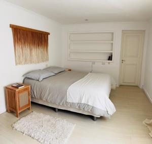 a bedroom with a bed and a table and a window at Las Margaritas in Ushuaia