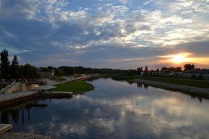 a view of a river with the sun setting at Loftson Apartament in Konin