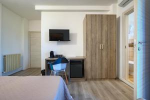 a room with a bed and a desk and a television at Hotel Anna in Siena