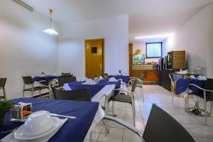 a dining room with blue tables and chairs at Hotel Anna in Siena