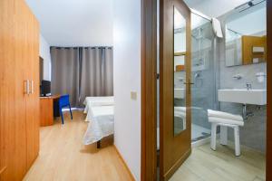 a bathroom with a shower and a sink and a bed at Hotel Anna in Siena +156 photos