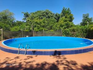 a large blue swimming pool in a yard at Las Cabañas in Santo Tomé +8 photos
