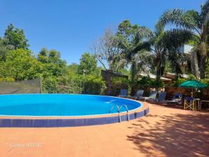 a swimming pool in a yard with chairs and trees at Las Cabañas in Santo Tomé