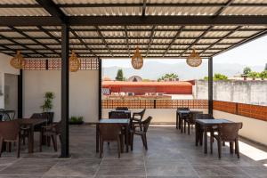 a restaurant with tables and chairs and a balcony at Hotel Mayis in Oaxaca City