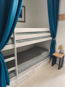 a bedroom with two bunk beds with blue curtains at Notre location au Barcarès in Le Barcarès +114 photos