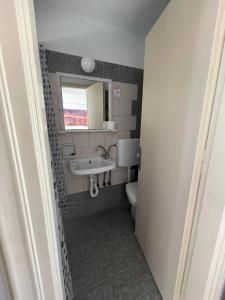 a bathroom with a sink and a toilet at Panorama Hotel in Kalymnos