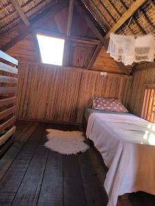 a bedroom with a bed and a window in a cabin at Erina Beach in Antalaha