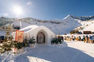 a small building in the snow with a crowd of people at Huntley Lodge at Big Sky Resort in Big Sky