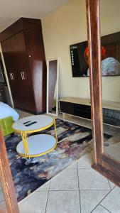 a room with a table and a bed and a tv at Ocean View Villas F3 in Port Edward