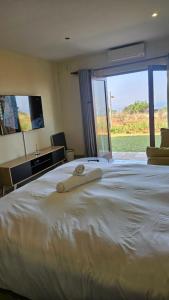 a bedroom with a large white bed with a large window at Ocean View Villas F3 in Port Edward +18 photos