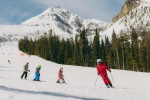a group of people skiing down a snow covered mountain at Huntley Lodge at Big Sky Resort in Big Sky
