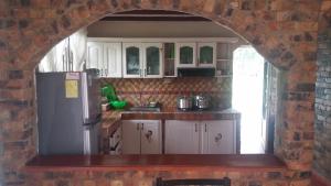 una cocina con armarios blancos y una pared de ladrillo en Finca Villa Patricia, en Paipa