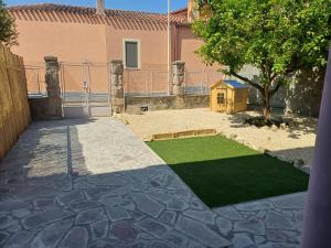 a backyard with a yard with a grassy lawn at Domos Ventuno Barumini in Barùmini