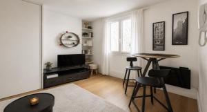 a living room with a table and a television at Maisonn La Turbie - Privateee pool in La Turbie