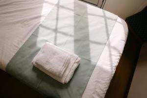 a white towel sitting on top of a bed at Hospedaria Canto do Rossio in Vidigueira