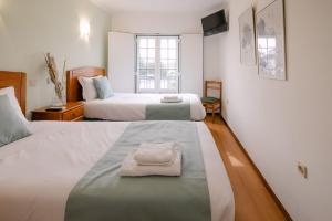a bedroom with two beds with towels on them at Hospedaria Canto do Rossio in Vidigueira