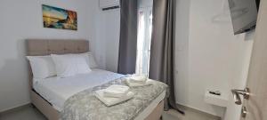 a small bedroom with a bed with towels on it at Alexandras Maisonette in Skiathos