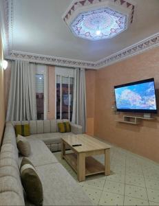 a living room with a couch and a flat screen tv at Morjan apart in Tangier
