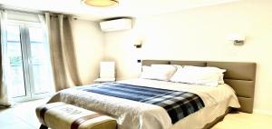 a bedroom with a bed with a blue and white blanket at Maisonn La Turbie - Privateee pool in La Turbie