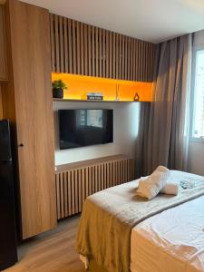 a bedroom with a bed and a flat screen tv at Flat 503 - America in Campos dos Goytacazes +13 photos
