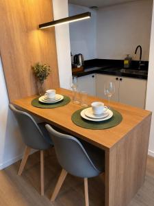 a dining room table with two plates and wine glasses at Flat 503 - America in Campos dos Goytacazes