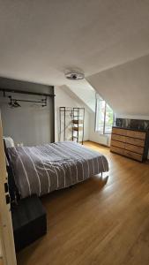a bedroom with a bed and a wooden floor at Résidence Le Soleil de Nousty in Nousty