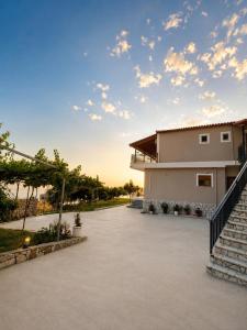 a house with a staircase next to a driveway at Villa Çela in Lukovë