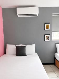 een slaapkamer met een groot bed met een witte sprei bij Adhoc Macro in Monterrey