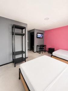 ein Schlafzimmer mit einem weißen Bett und einer rosa Wand in der Unterkunft Adhoc Macro in Monterrey