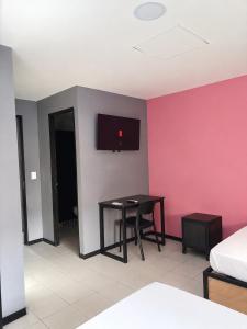 een kamer met een tafel en een tv aan de muur bij Adhoc Macro in Monterrey
