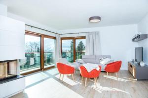 a living room with a table and red chairs at Villa Valentine in Flachau