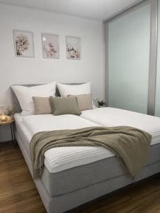 a bedroom with a large bed with white walls at See- & Bergblick Oberteuringen 59 mit beheiztem Indoor-Pool in Oberteuringen