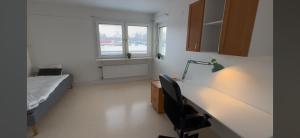 a bedroom with a bed and a desk with a lamp at Mangatan 2 in Borlänge