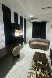 a living room with a couch and a television at Eraton Hotel in Warri