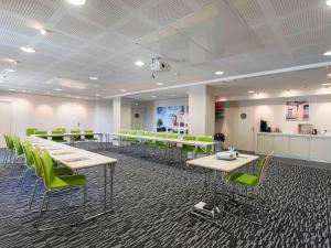 a conference room with tables and green chairs at Mercure Granville Le Grand Large in Granville
