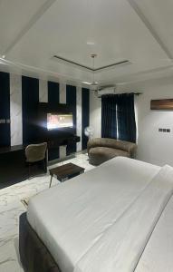 a bedroom with a large bed and a living room at Eraton Hotel in Warri